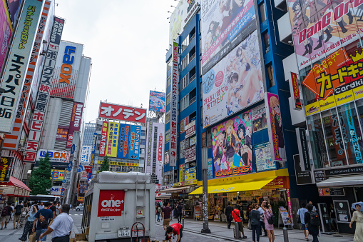 Tokyo,Japan-August 22,2017: Crowds pass below colorful signs in Akihabara. The well known electronics district specializes in the sales of video games, anime, manga, and computer goods.