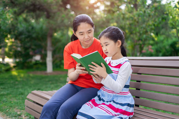 istock Little Girl and Mother Reading Book 1331100209