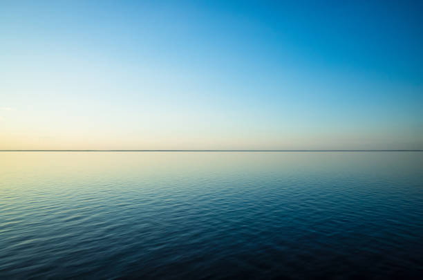 istock Tranquil minimalist landscape with a smooth blue sea surface with calm waters with a horizon and clear skies 1331100527