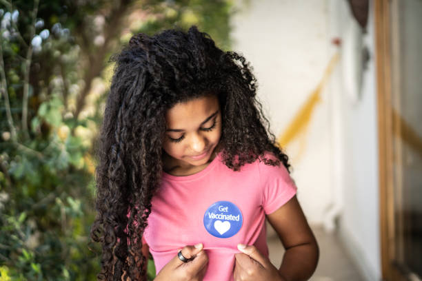 istock Girl looking at her 'Got vaccinated' sticker on her shirt 1331100783