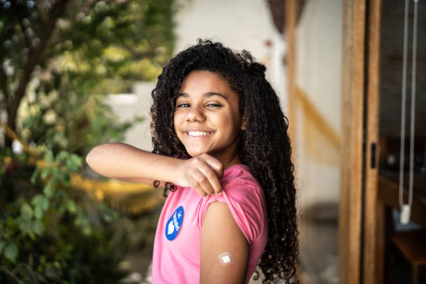 Portrait of girl showing ar after vaccination Portrait of girl showing ar after vaccination bandage photos stock pictures, royalty-free photos & images