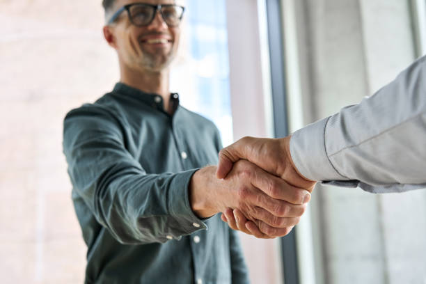 istock Two happy professional businessmen shaking hands at meeting. Handshake 1331101162
