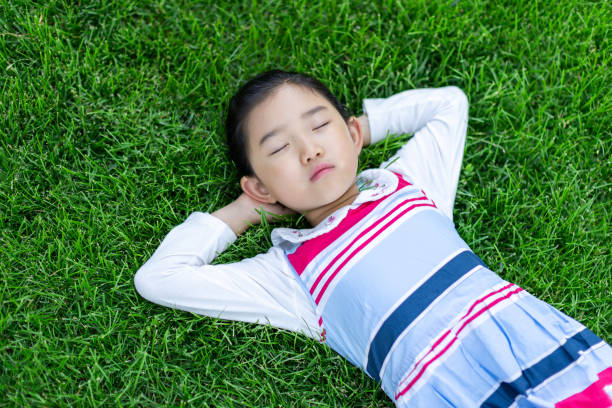 istock Cute girl Lying Down on the Grass 1331101917