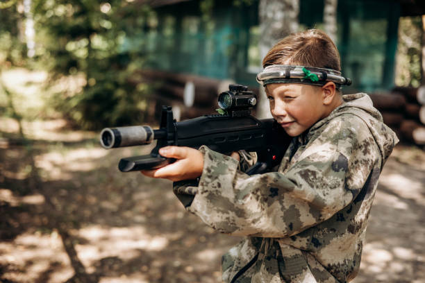 istock Boy looking into the optical sight a weapon. Children playing laser tag shooting game in outdoor. War simulation game 1331102176