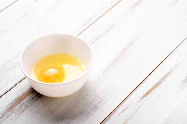 istock Raw egg in a plate on a white wooden background. 1331102329