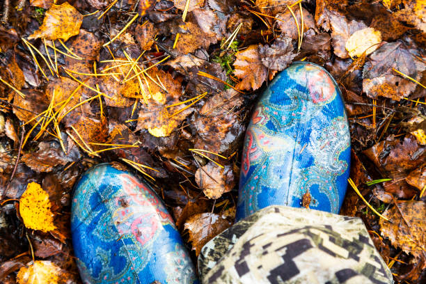 blue rubber boots on the background of autumn fallen leaves