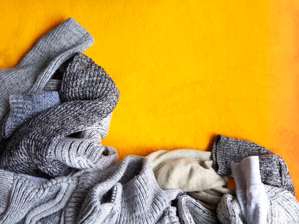 istock Warm knitted jumpers and sweaters on bright yellow background 1331106423