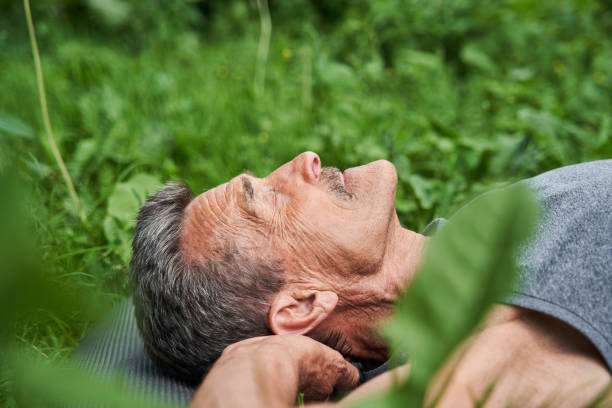 istock Mature man doing relaxing yoga pose while laying on the mat at the nature 1331109140