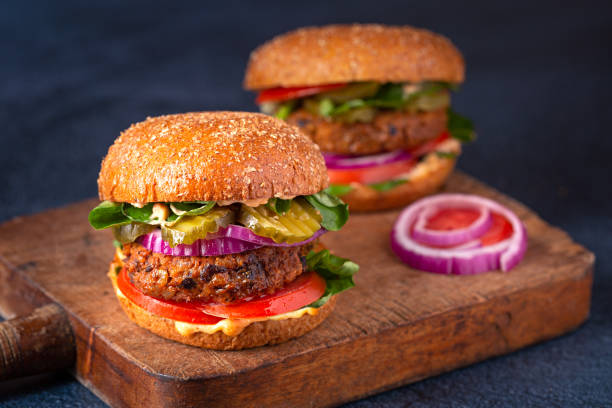 istock Two veggie burgers on a rustic cutting board 1331109170