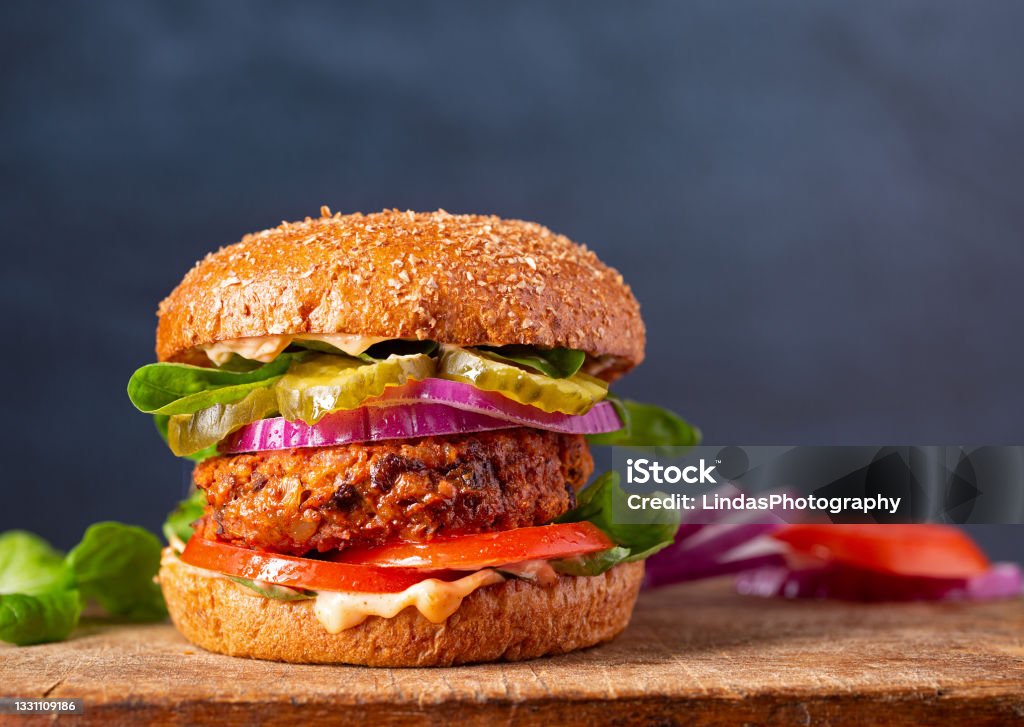 Close-up of a veggie burger with copy space Homemade plant based burger made from sweet potato, black beans and brown rice on a whole wheat brioche bun; copy space Veganism Stock Photo