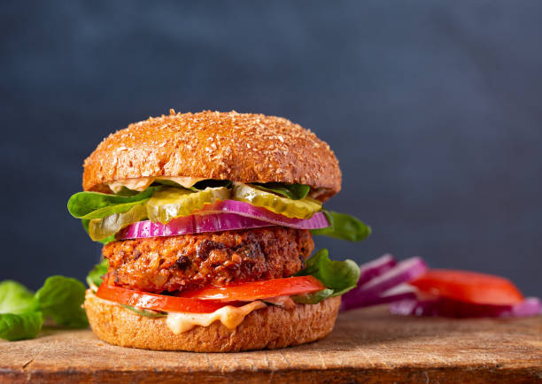Close-up of a veggie burger with copy space Homemade plant based burger made from sweet potato, black beans and brown rice on a whole wheat brioche bun; copy space burgers stock pictures, royalty-free photos & images