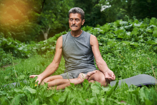 istock Man practicing yoga and doing ardha padmasana exercise while sitting on lotus position 1331109250