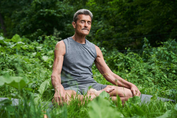 istock Caucasian mature man meditates while practicing yoga at the mat 1331109651