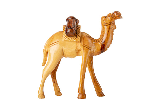 Closeup of a wooden handmade carved camel carrying two barrels isolated on white background.