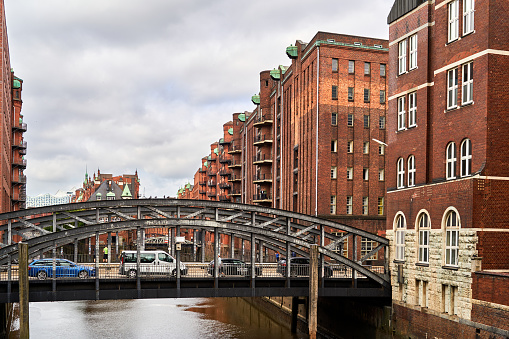 Hamburg, Germany, July 22, 2021: Cast iron historical bar arch bridge over a canal in Speicherstadt