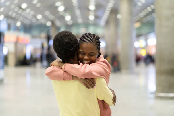 Family reunion in airport. Happy black male hugging excited woman after plane arrival in terminal Family reunion in airport. Happy black male hugging excited woman after plane arrival in terminal. Loving coule met after covid-19 epidemic lockdown. Romantic male and female embrace after trip abroad airport hug stock pictures, royalty-free photos & images