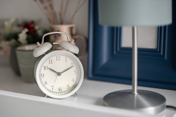 istock White alarm clock on bed table in bedroom. 1331111784