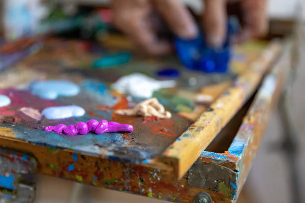 istock Closeup of hand mixing paint on palette at workshop 1331112968