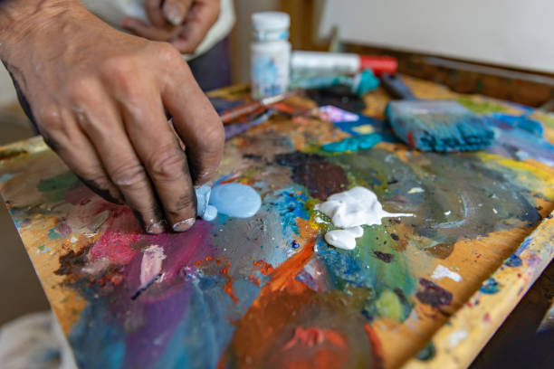 istock Closeup of hand mixing paint on palette at workshop 1331112975