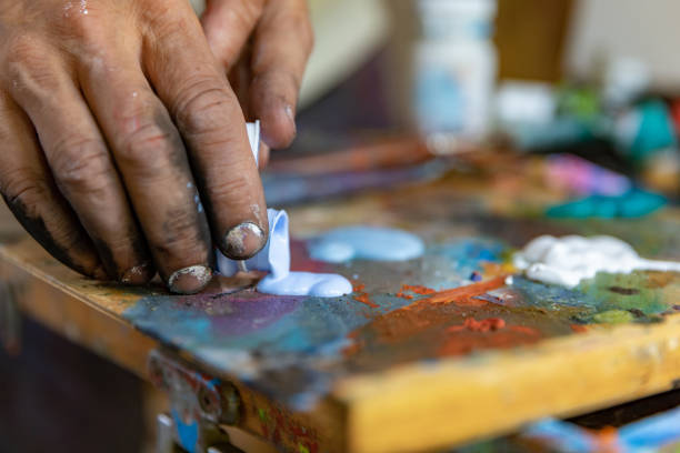 istock Closeup of hand mixing paint on palette at workshop 1331112996