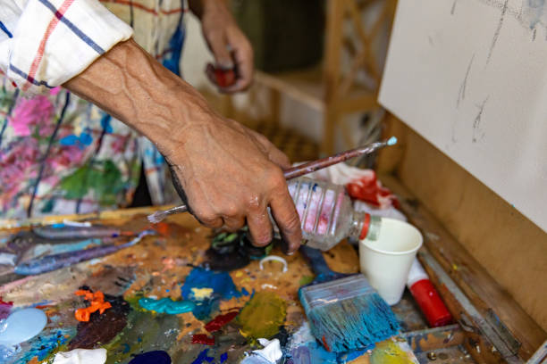 istock Closeup of hand mixing paint on palette at workshop 1331113001