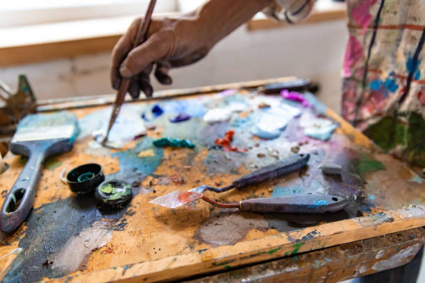 istock Closeup of hand mixing paint on palette at workshop 1331113032