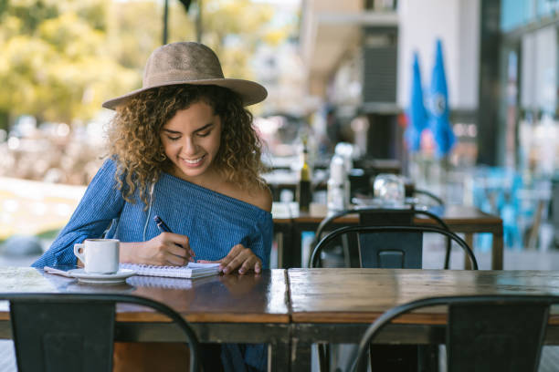 istock Woman writing on a notebook at a coffee shop. 1331113096