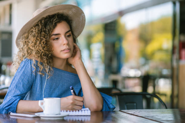 istock Woman writing on a notebook at a coffee shop. 1331113568