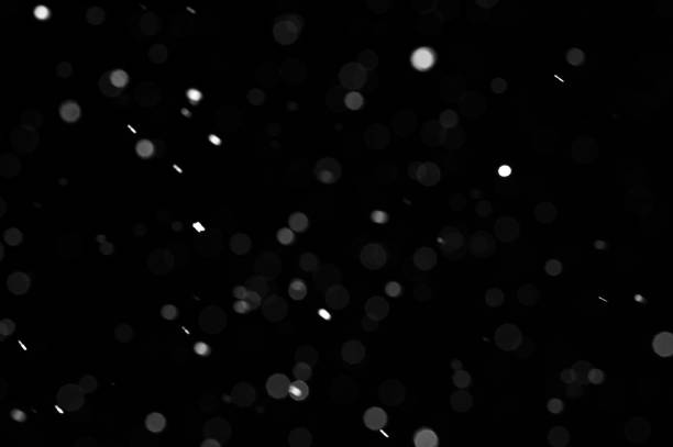 istock Bokeh of white snow on a black background. Snowfall - design element. 1331114505