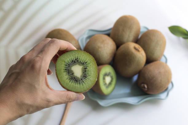 istock fresh cut green kiwi fruit isolated on white. 1331114603