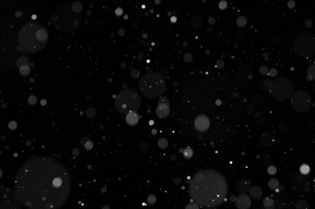 istock Bokeh of white snow on a black background. Snowfall - design element. 1331114693