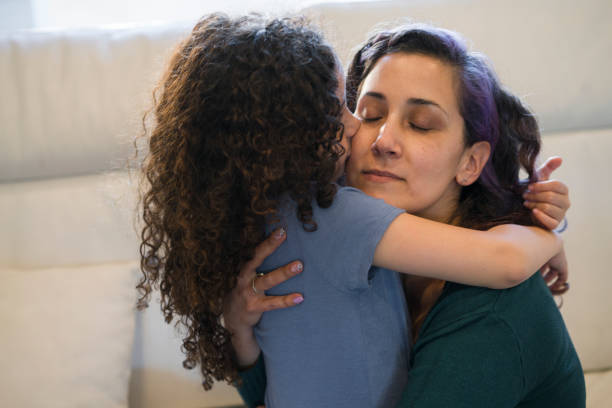 istock Mother and daughter hugging on sofa 1331119932