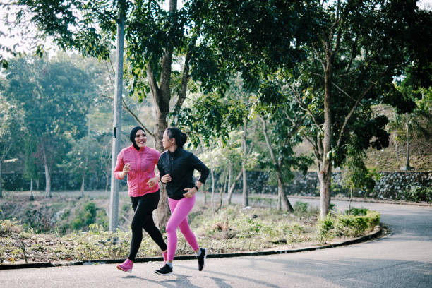 belle mère et fille faisant du jogging ensemble au parc - running jogging asian ethnicity women photos et images de collection