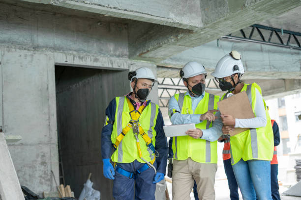istock two engineers walk through the construction site that they lead talking to one of the workers in charge of construction issues 1331127521