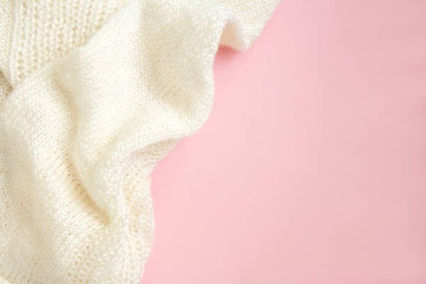 istock Folds white knitted fabric on pastel pink background 1331128477