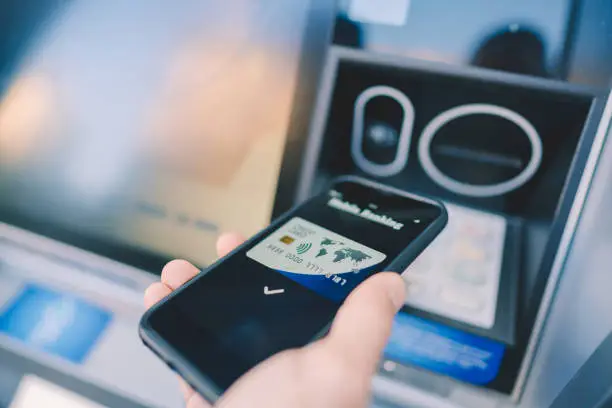 Photo of Man at the ATM withdrawing money with smartphone