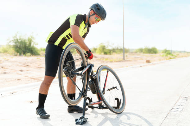 jovem ajustando sua bicicleta para começar a treinar - pedal bicycle sports training cycling - fotografias e filmes do acervo