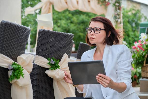 istock Woman professional decorator with digital tablet working outdoors decorating ceremony 1331133383
