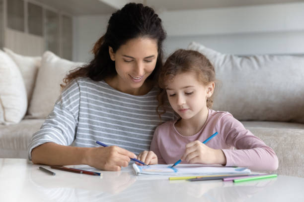 istock Happy Latino mom and small daughter drawing 1331134339