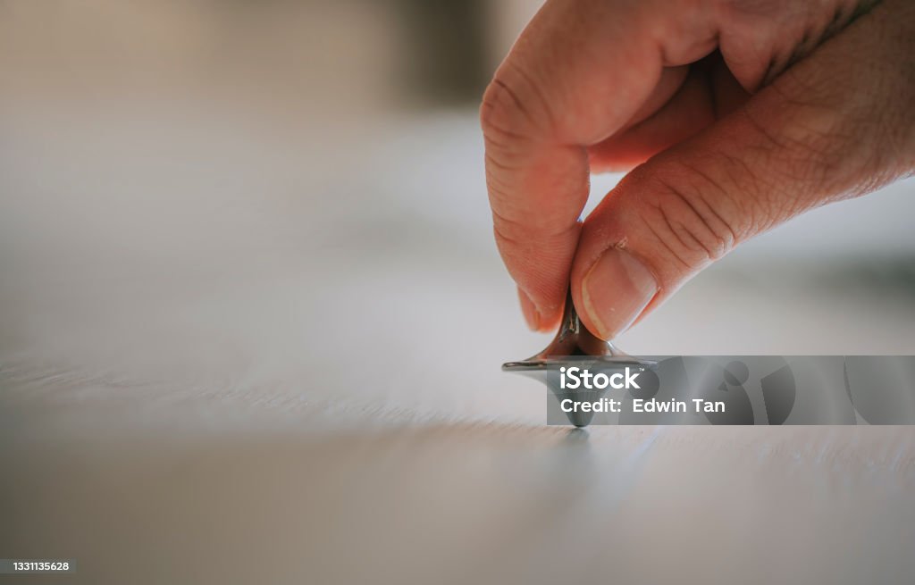Spinning toy Gyroscope Die Cast Spinning Top on hardwood flooring Spinning Top Stock Photo
