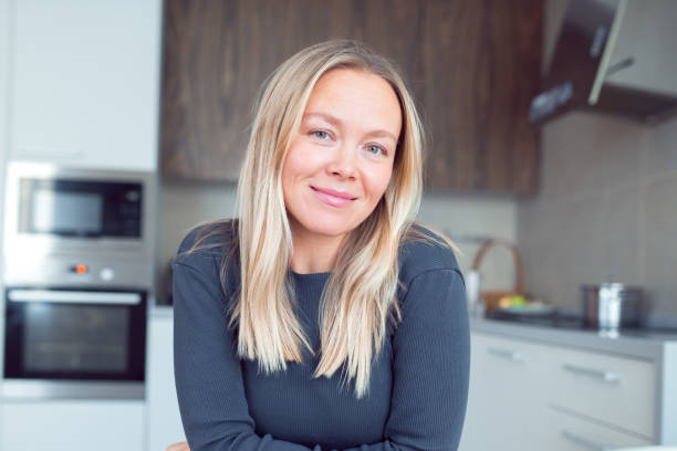 istock Beautiful blonde woman sitting at kitchen 1331135845