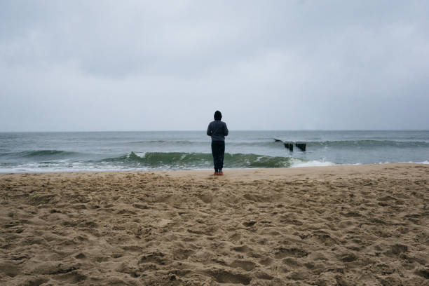 istock Rear View Of Man Standing On Beach 1331138888