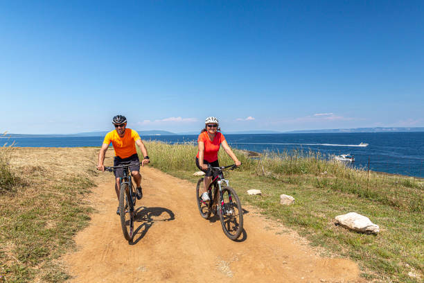 istock People Riding Bicycle By Sea Against Sky 1331139136