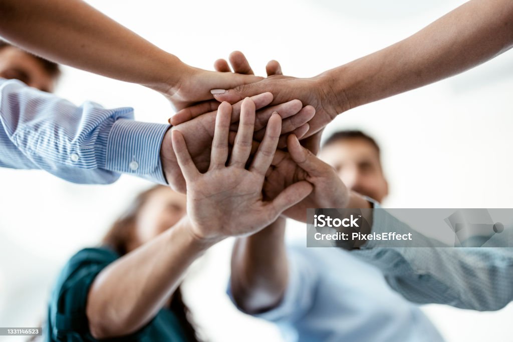 Work together to win together Close view of multi ethnic business people stacked palms together as concept of corporate unity, connection, team building loyalty Team Building Stock Photo