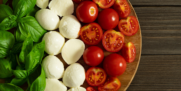 Italian food flag banner. Ingredients for the caprese salad: basil, cherry mozzarella and tomato. Concept of Italian food. Fresh summer appetizer.