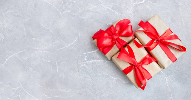 istock Gift boxes with a red bow on concrete background. Banner. Copy space. Flat lay. Top view. The concept of any holiday 1331149322