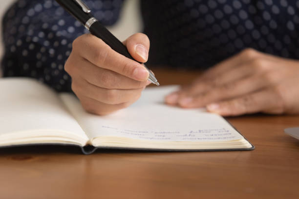 istock Close up woman taking notes in notebook, holding pen 1331150482