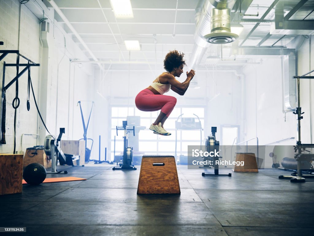 Woman in a Cross Training Gym A woman working out alone in a cross training gym. Exercising Stock Photo
