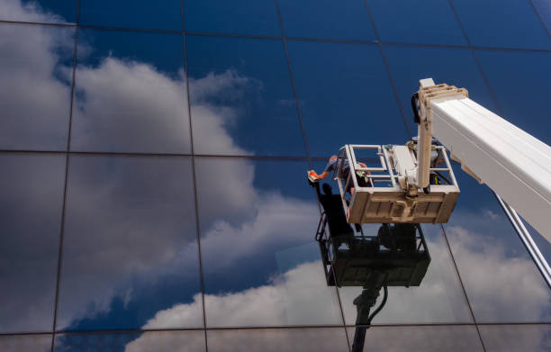 los trabajadores más limpios usan un selector de cerezas para limpiar una fachada que refleja el cielo nublado. - cleaning window window washer built structure fotografías e imágenes de stock