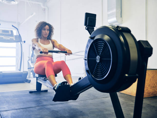 femme dans un gymnase d’entraînement croisé - appareil de musculation photos et images de collection